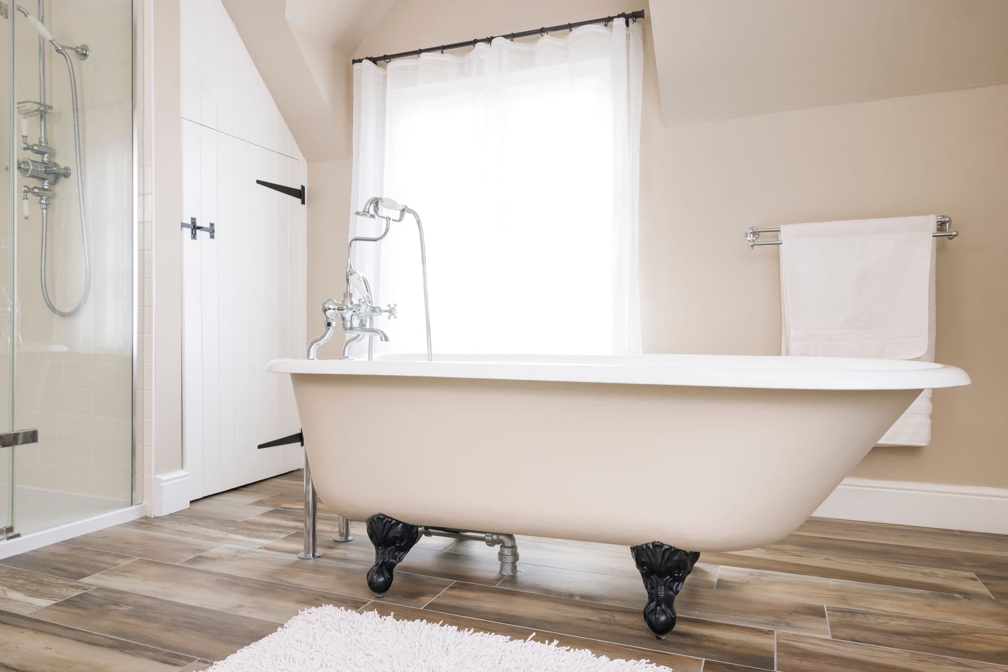 Roll-top bath on feet beneath a window