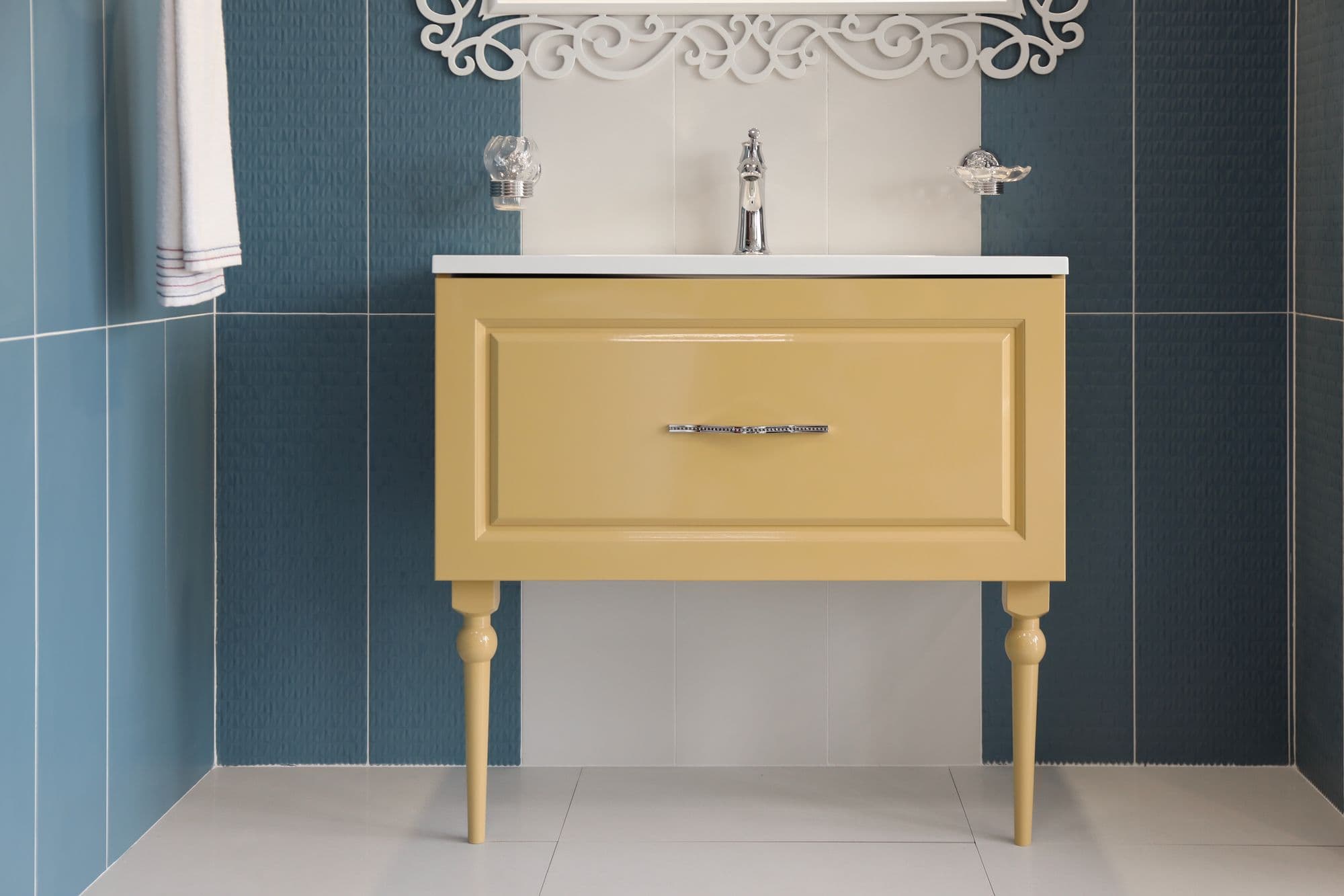 Yellow vanity unit against blue tiles
